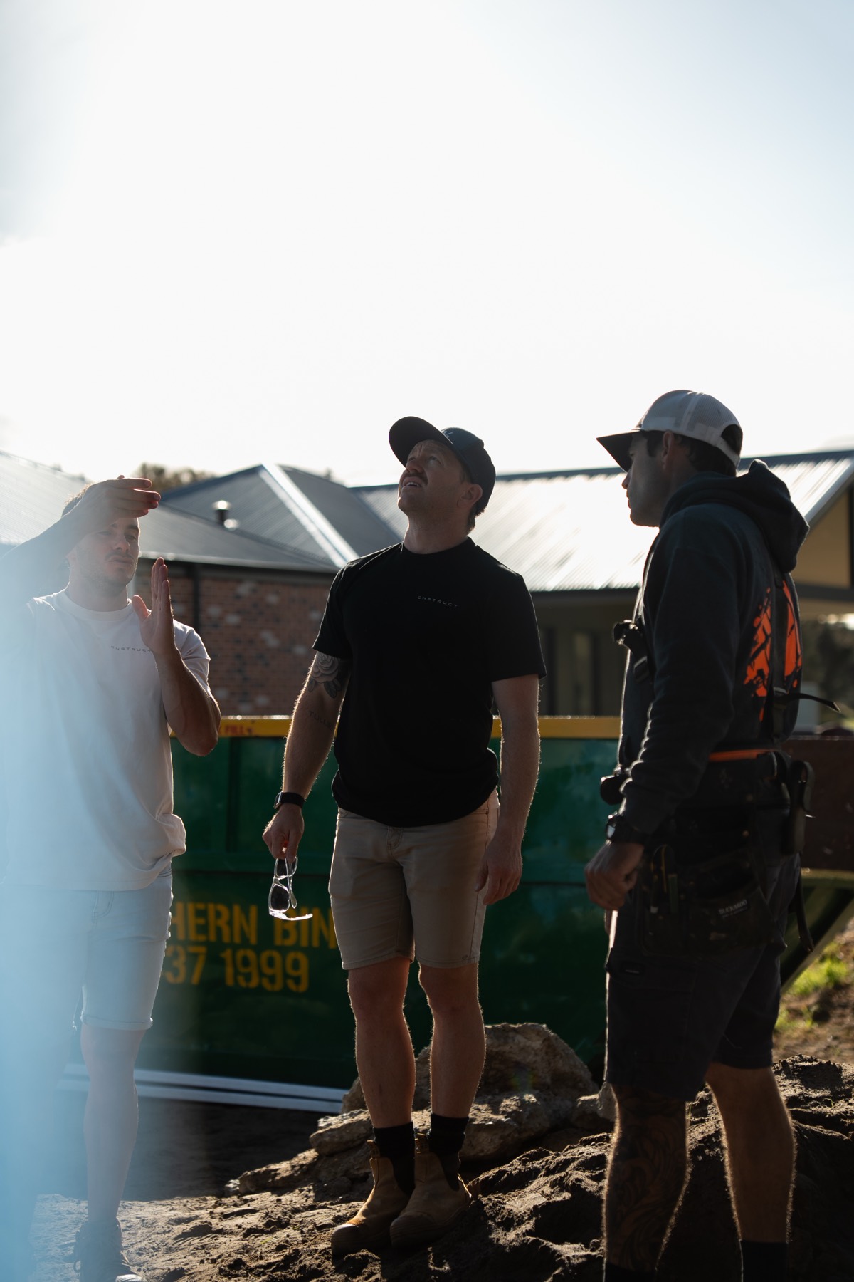 three tradies on-site wearing branded merch