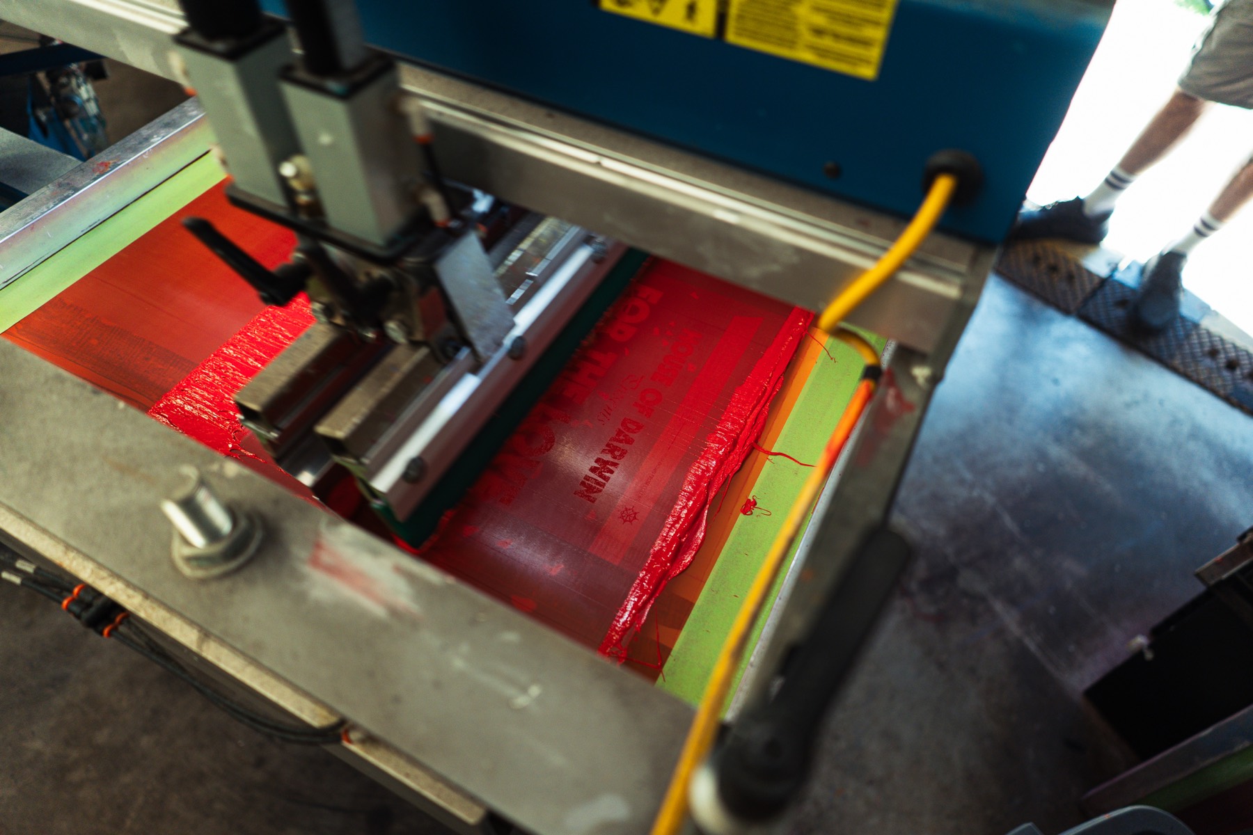 to the nines printing the house of darwin tee — red ink on the press